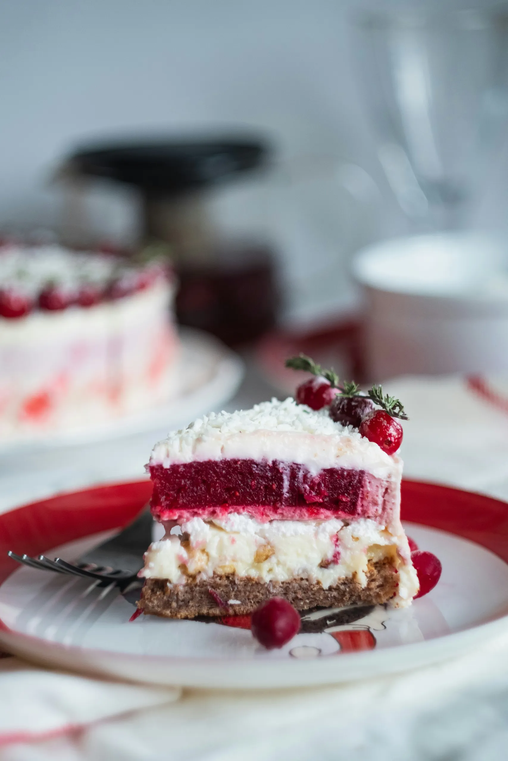 Porción de pastel de capas con arándanos rojos y coco rallado en un plato